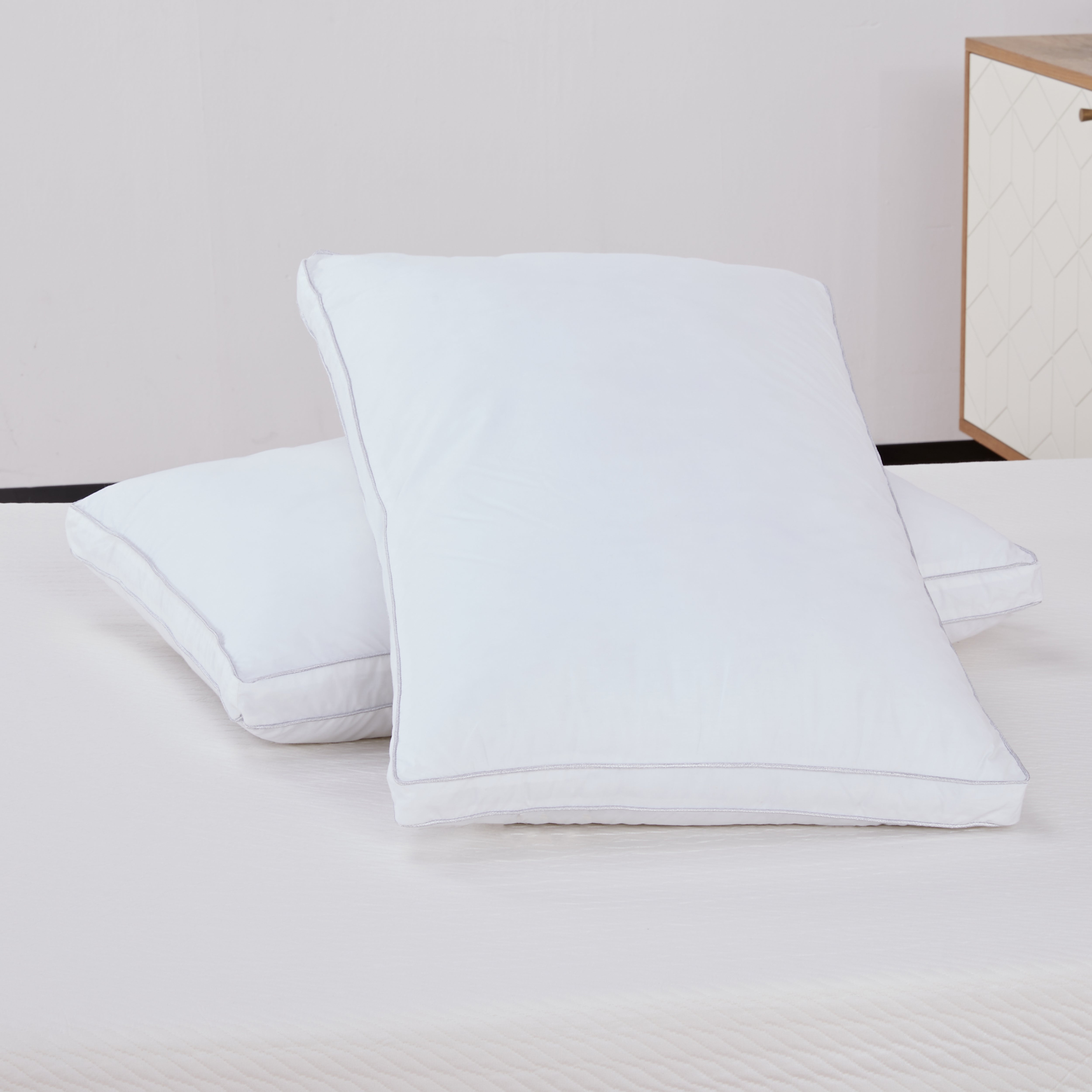 Set of two white bed pillows on a mattress