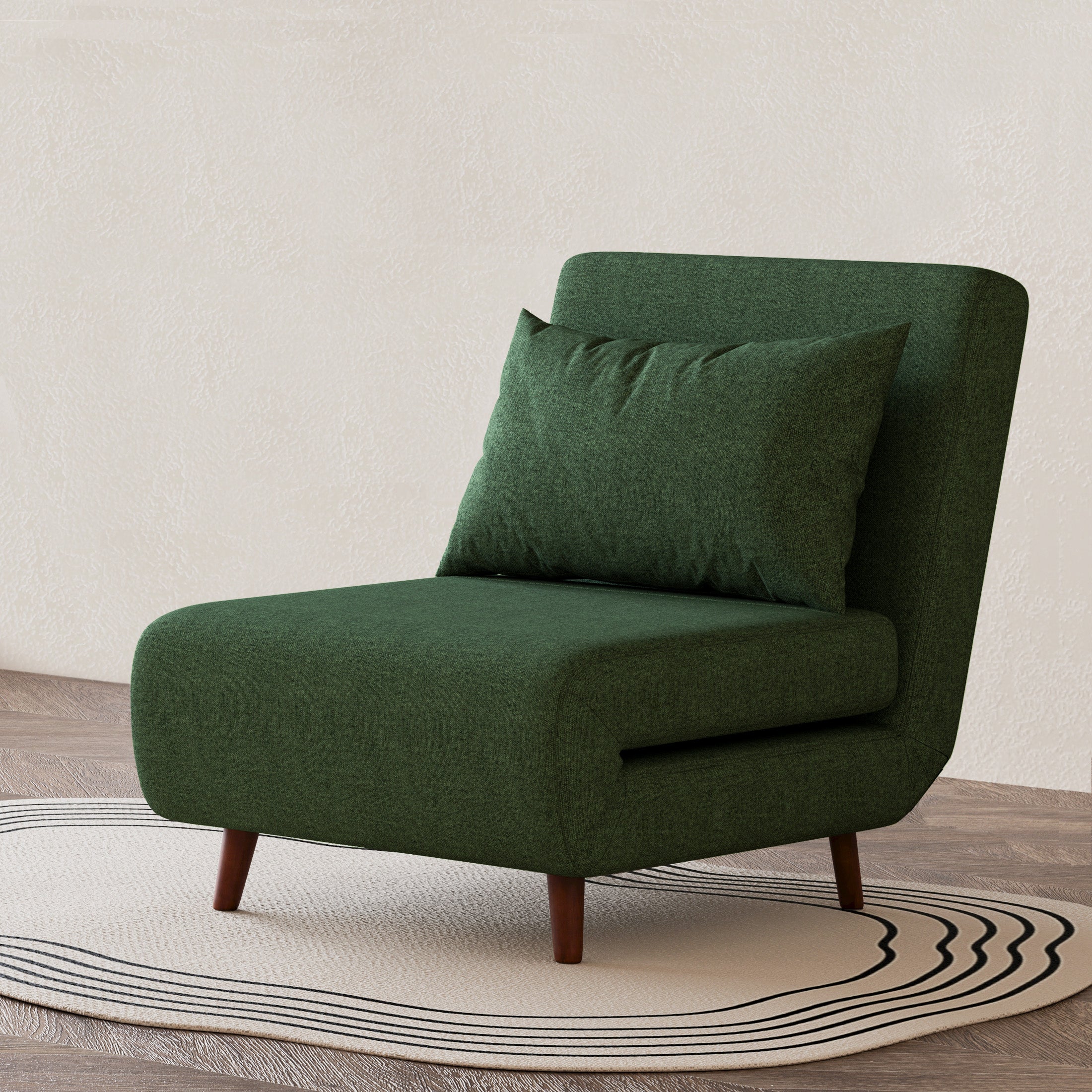 Tustin Convertible Chair in Green styled on a patterned rug with an armless silhouette, matching lumbar pillow, rounded seat, and tapered dark brown wood legs