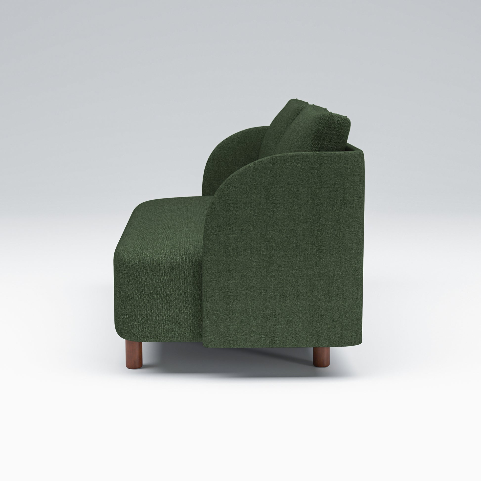 Nora Loveseat in Moss Green shown in profile with a deep upholstered seat, curved arm silhouette, loose back cushions, and low brown legs.