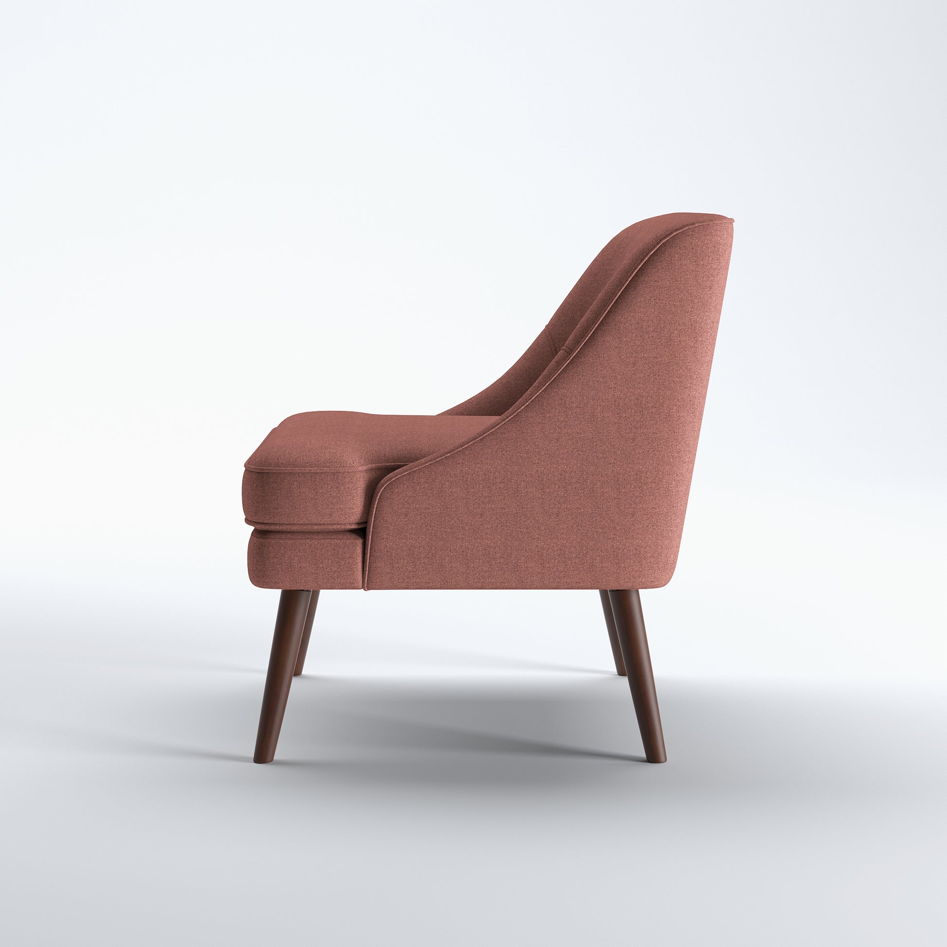 Dana Accent Chair in Faux Linen Dusty Rose shown from the side with a gently sloped back, integrated arm profile, thick seat cushion, and angled brown legs