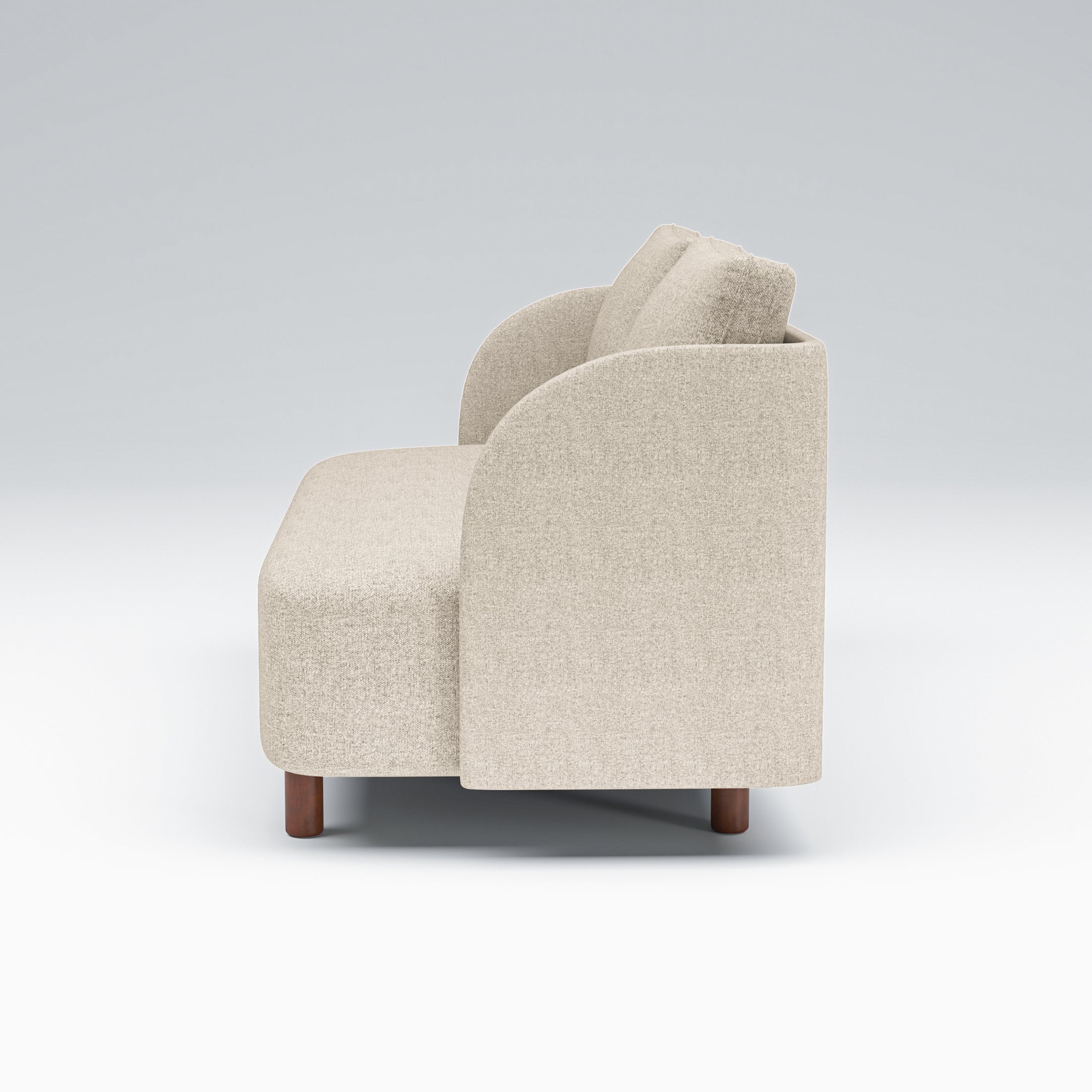 Nora Loveseat in Sandstone Beige shown in side profile, displaying the deep bench seat, curved arm panel, loose cushions, and short brown legs
