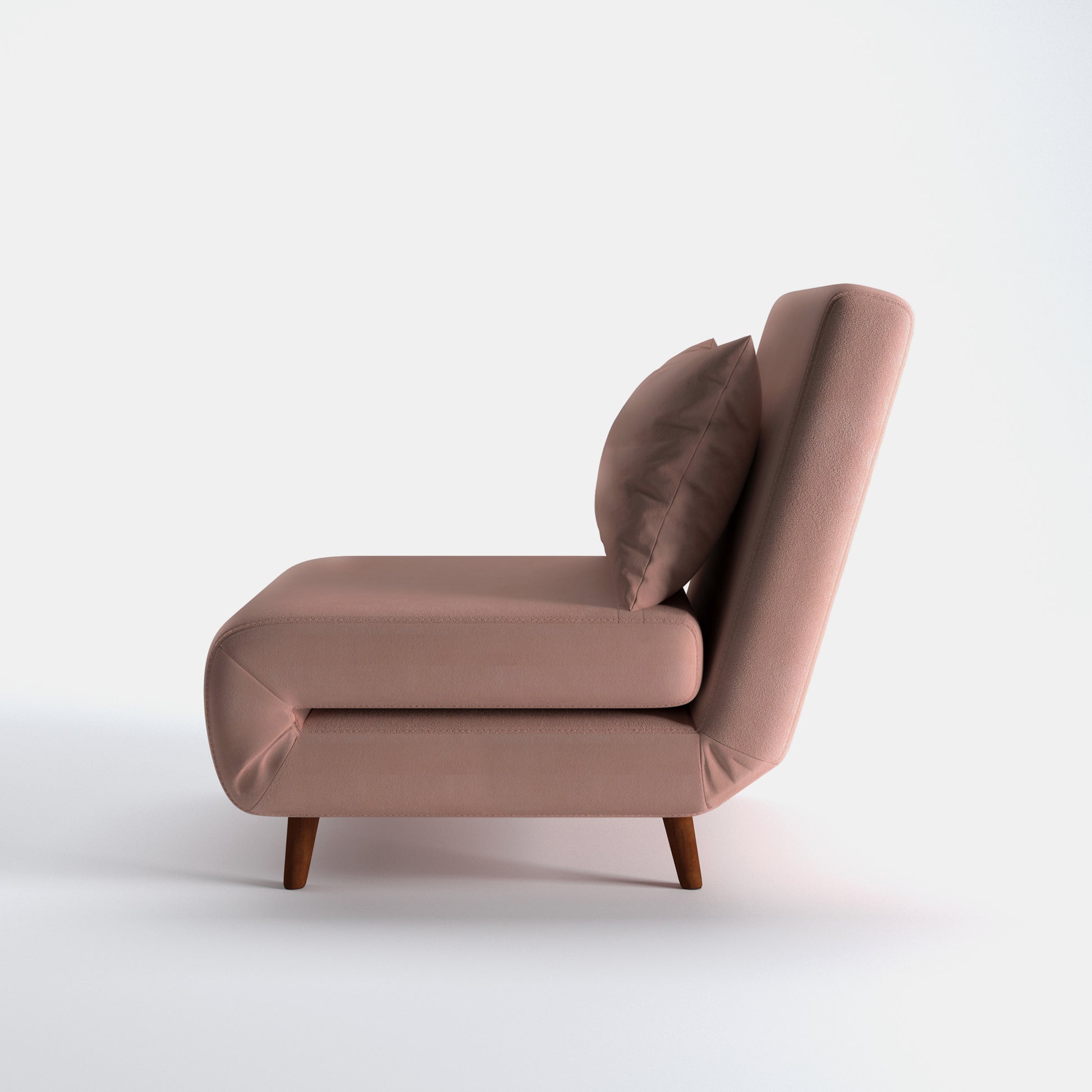 Tustin Convertible Chair in Velvet Blush shown from the side with a thick cushioned seat, reclining backrest, matching lumbar pillow, and tapered dark brown wood legs