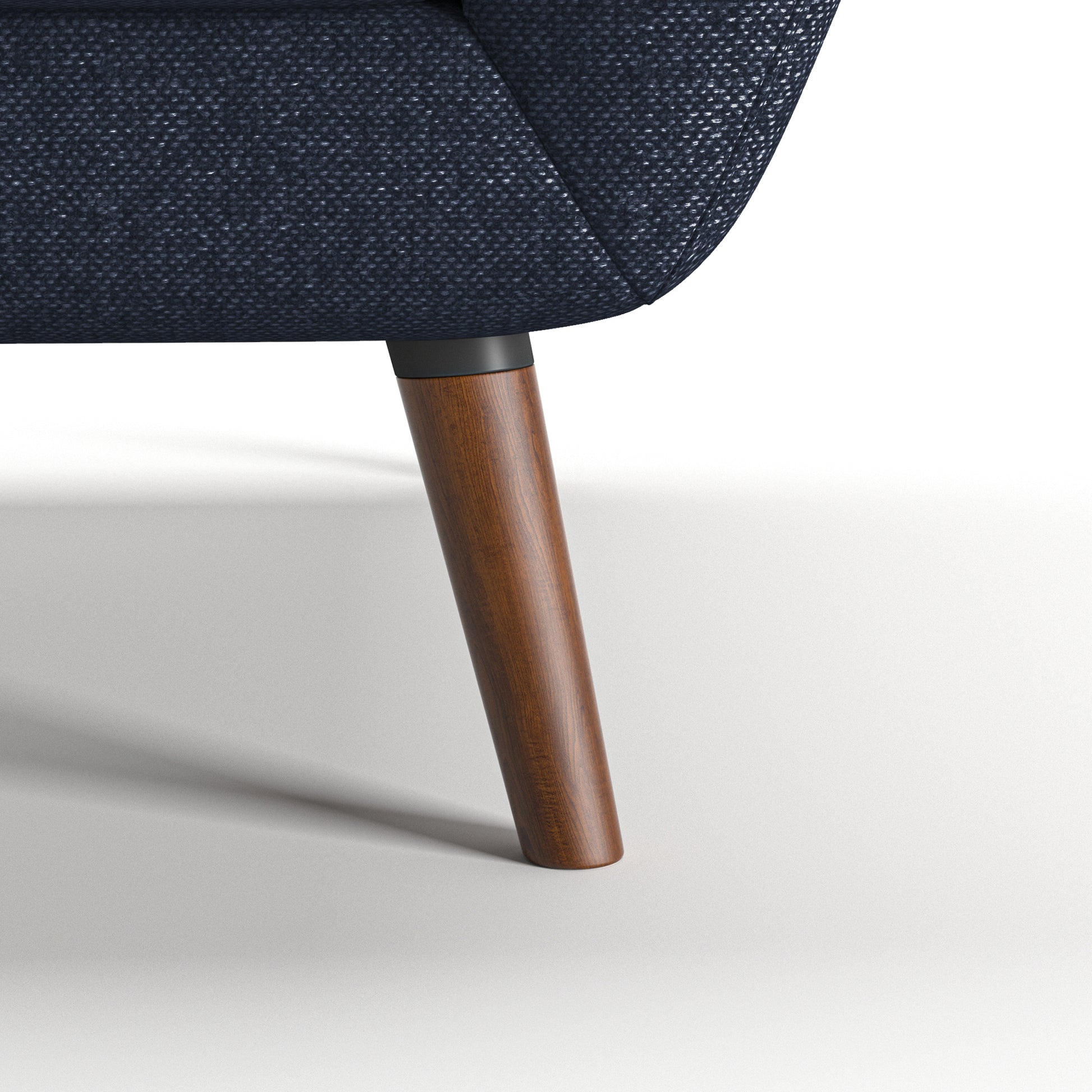 Oakland Loveseat in Navy Blue featuring a close-up of the tapered brown leg, dark connector, curved lower frame, and textured navy woven upholstery