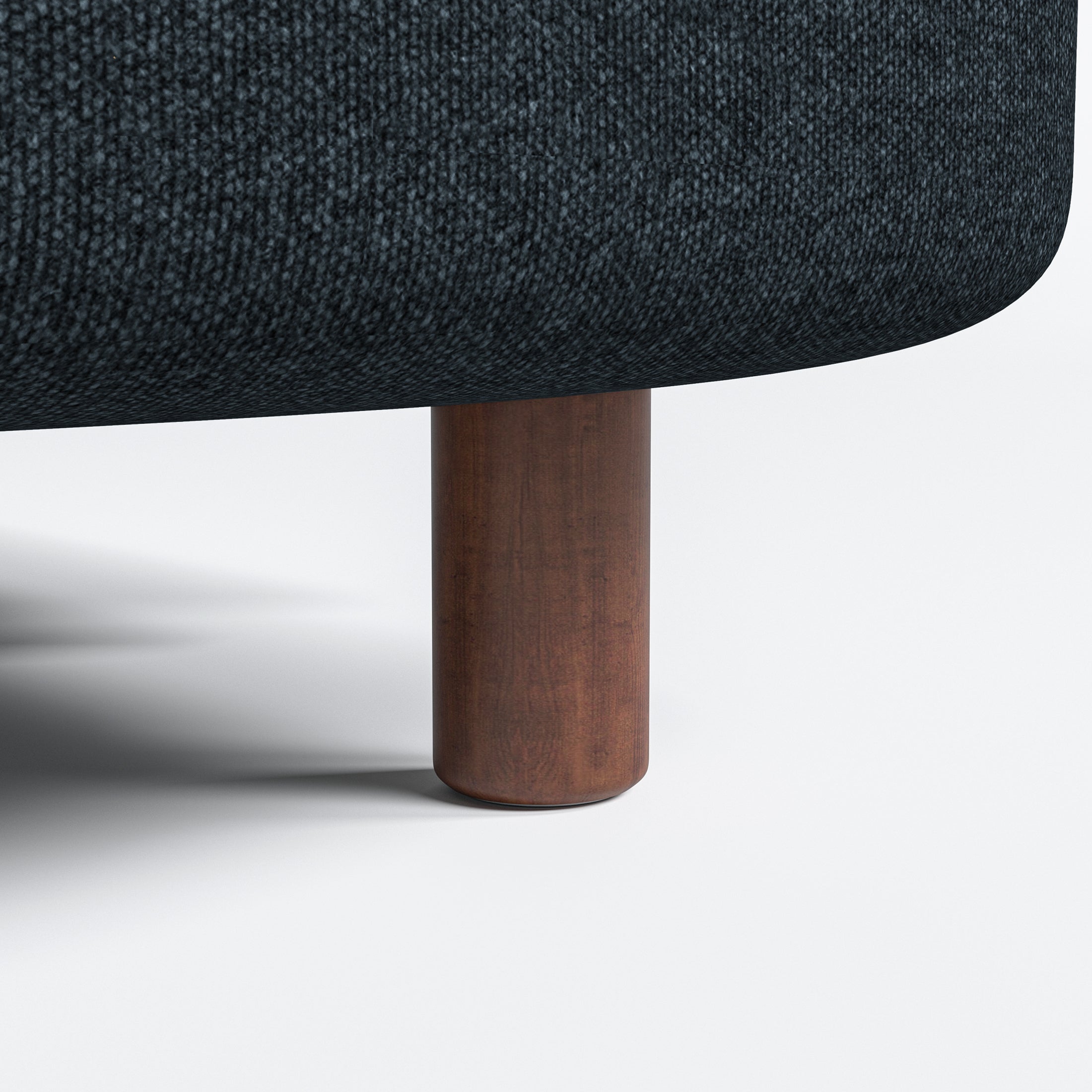 Nora Loveseat in Navy Blue featuring a close-up of the short brown cylindrical leg beneath the rounded base and dark woven upholstery