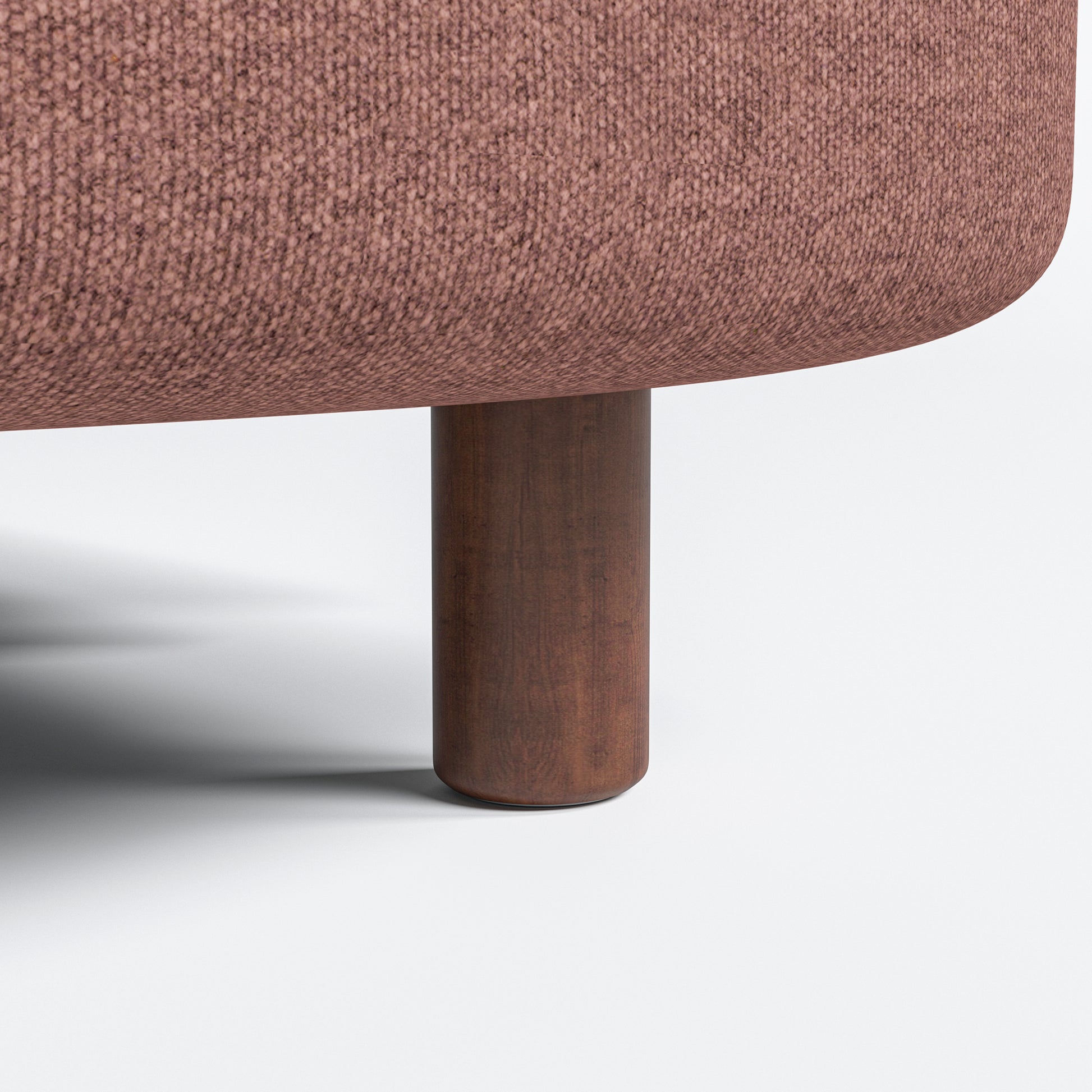 Nora Loveseat in Dusty Rose featuring a close-up of the brown cylindrical leg below the rounded base and textured rose-colored fabric.