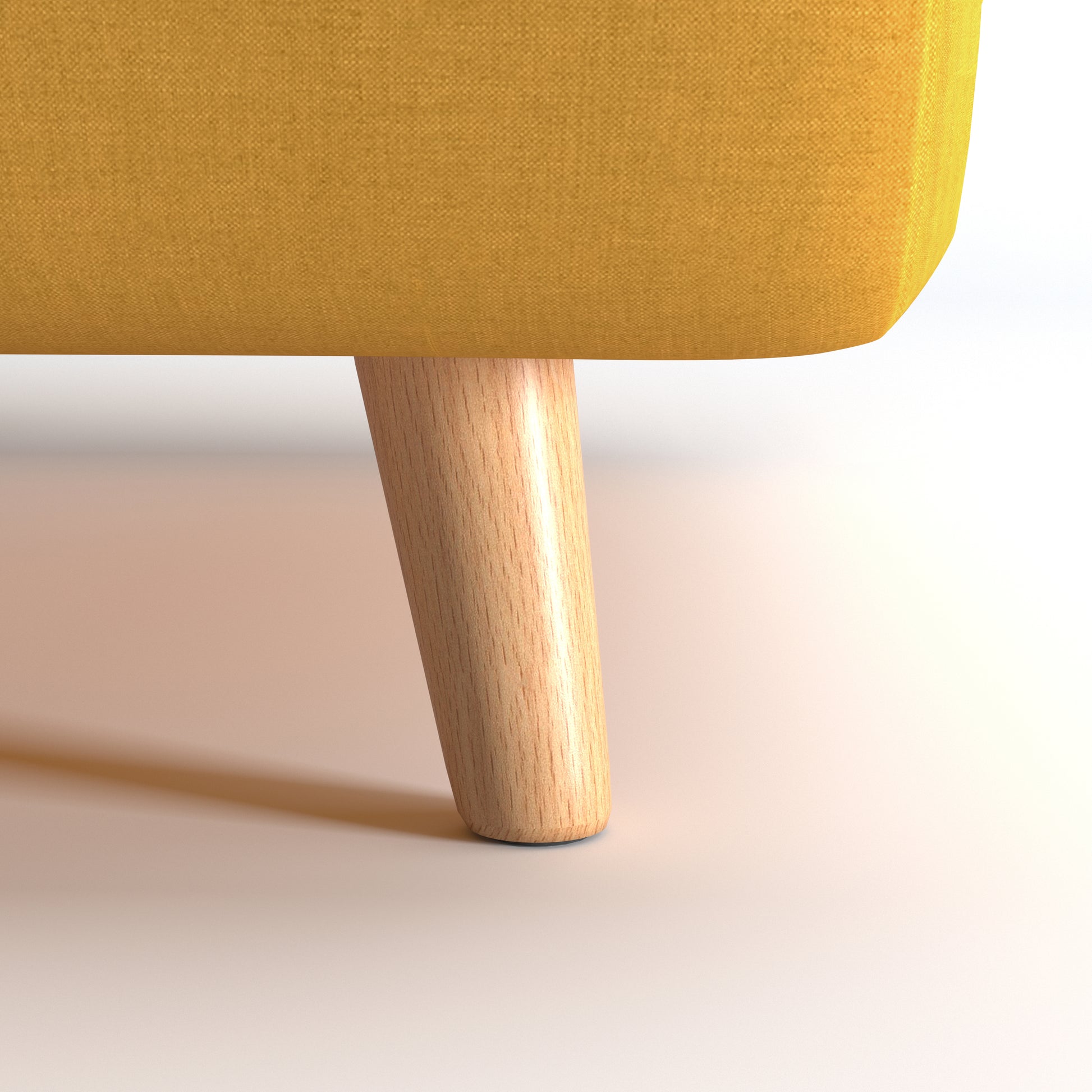 Tustin Convertible Chair in Mustard featuring a close-up of the tapered natural wood leg beneath the rounded base and textured mustard upholstery.