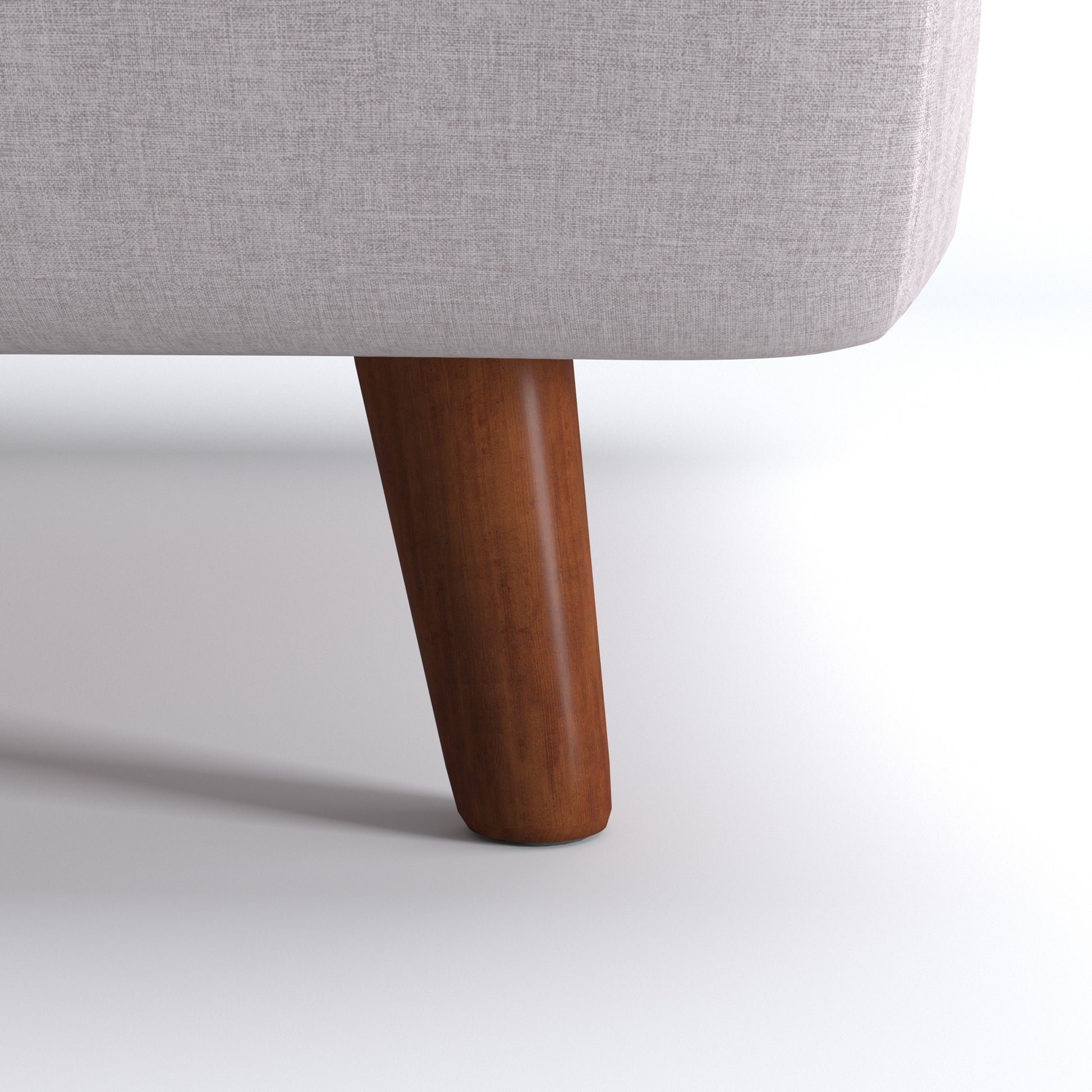 Tustin Convertible Chair in Beige featuring a close-up of the tapered dark brown wood leg beneath the rounded base and textured beige upholstery.