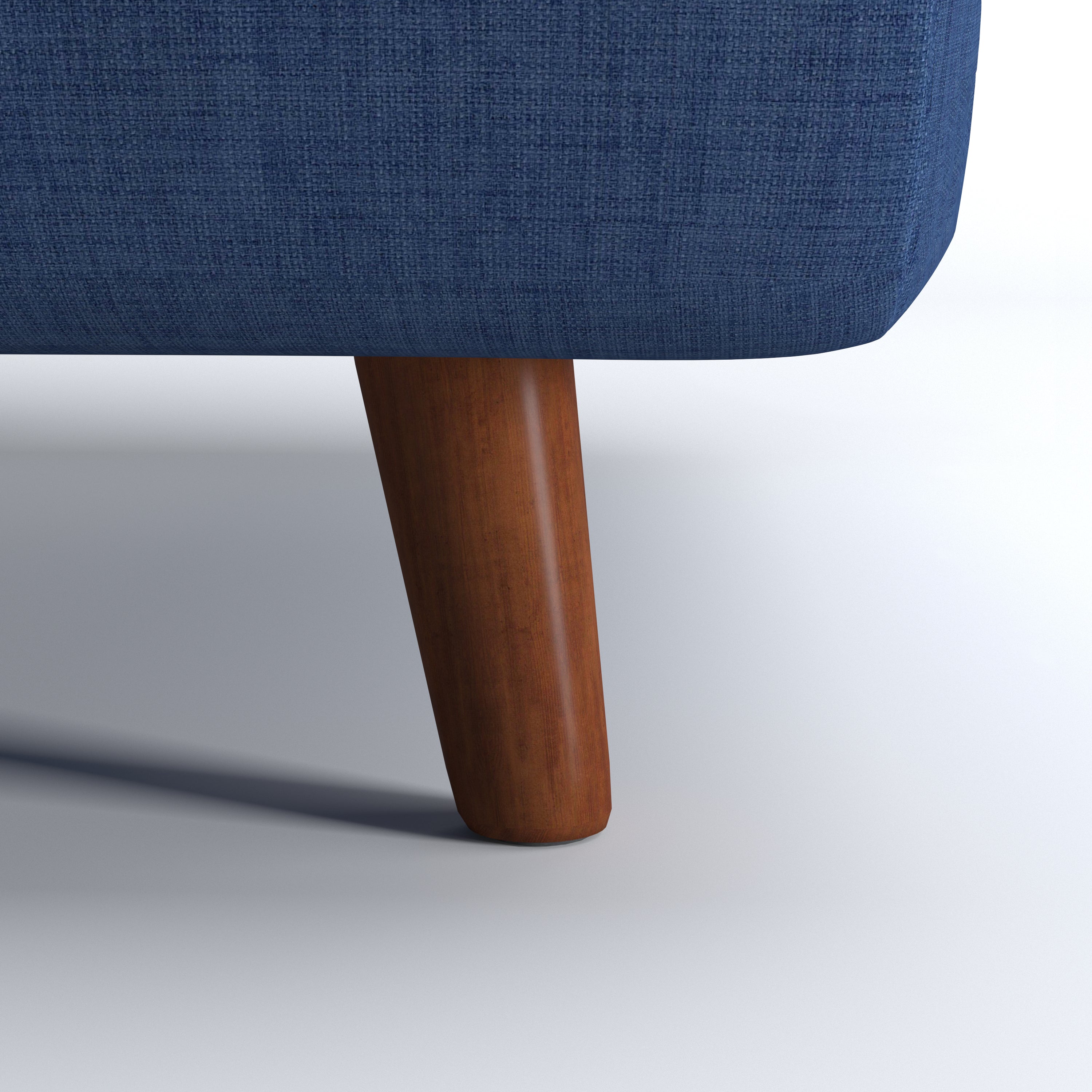 Tustin Convertible Chair in Blue featuring a close-up of the tapered dark brown wood leg beneath the rounded base and textured blue upholstery