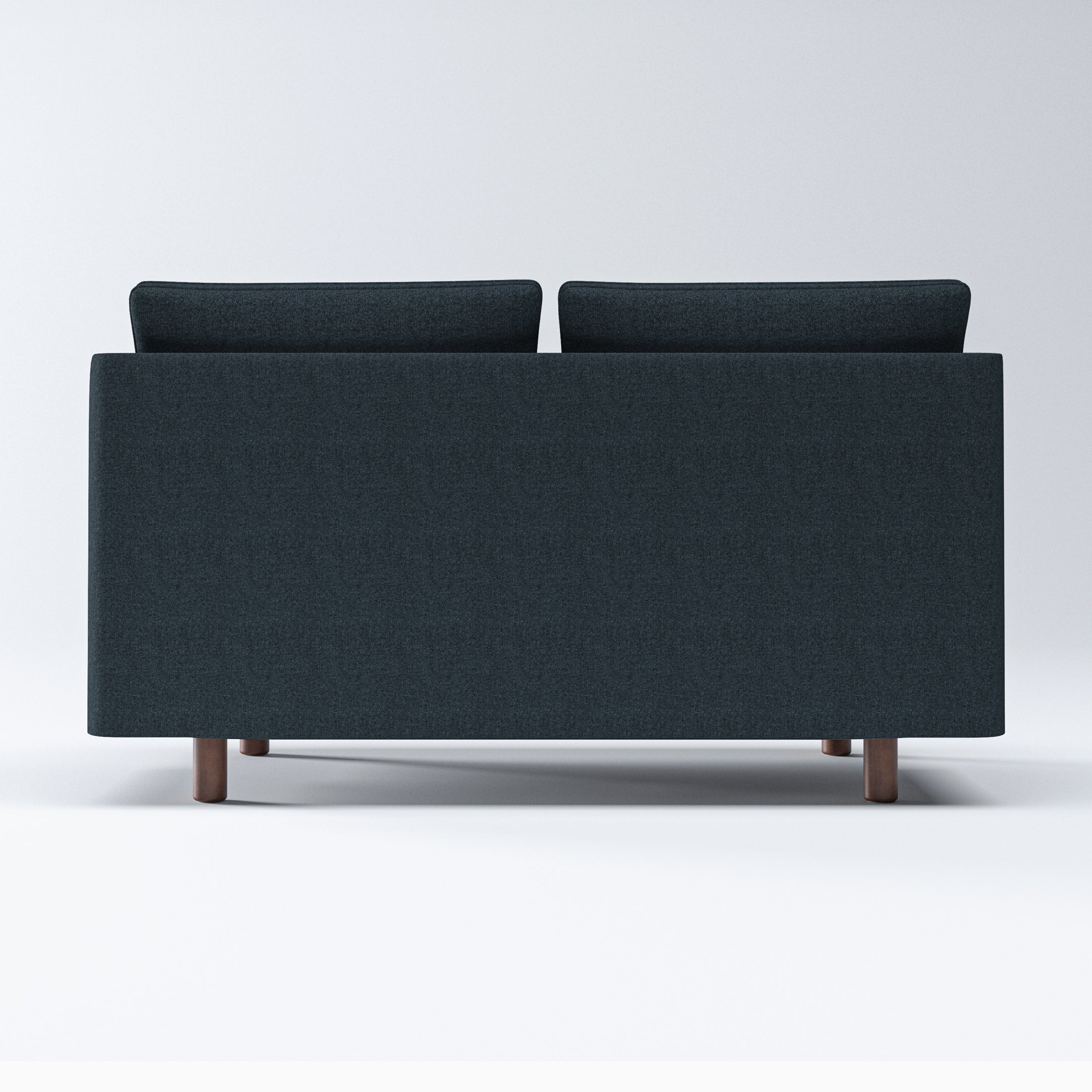 Nora Loveseat in Navy Blue shown from the rear, displaying a broad upholstered back panel, two raised back cushions, and short brown cylindrical legs.