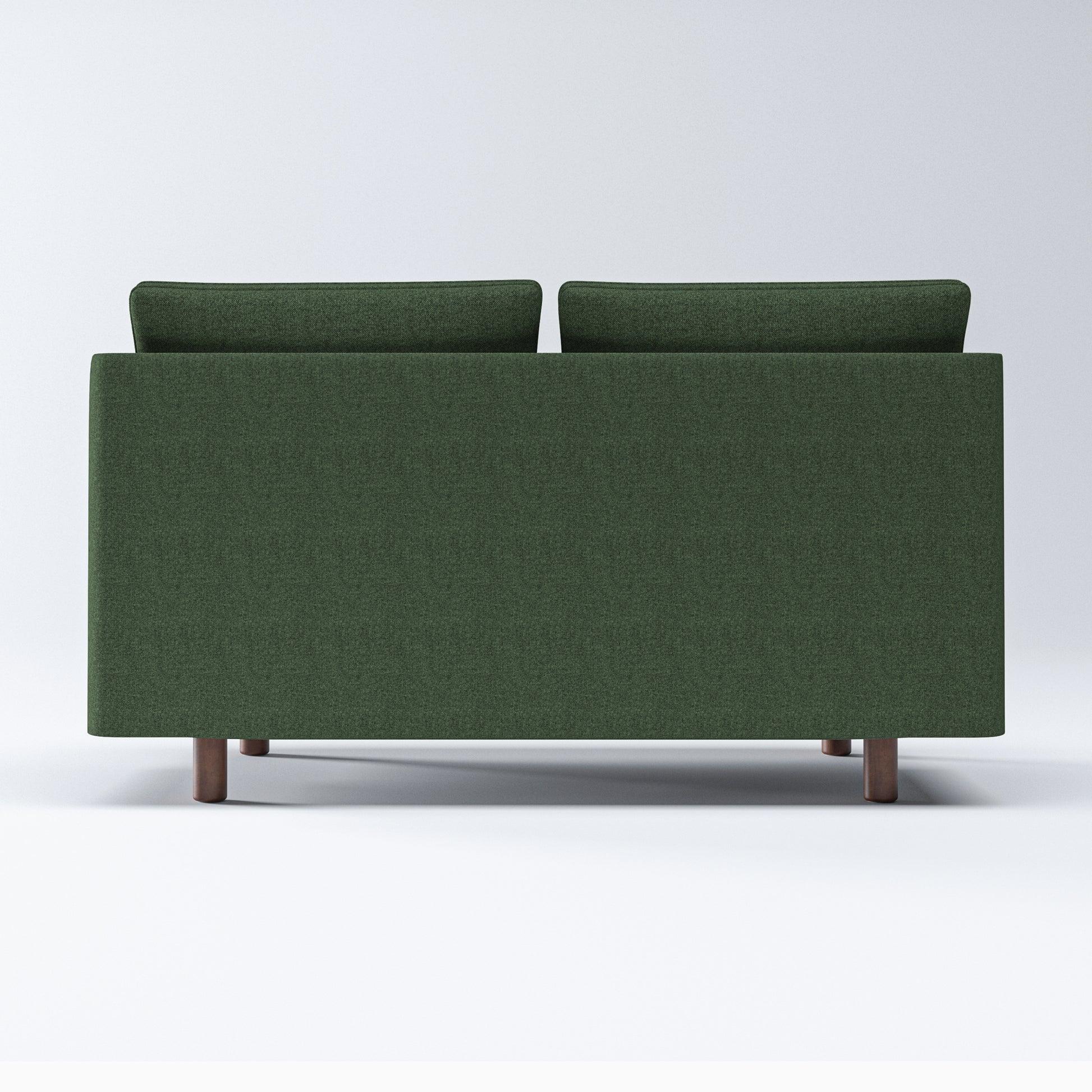Nora Loveseat in Moss Green shown from the back, displaying its wide upholstered rear panel, raised cushion edges, and four short brown legs