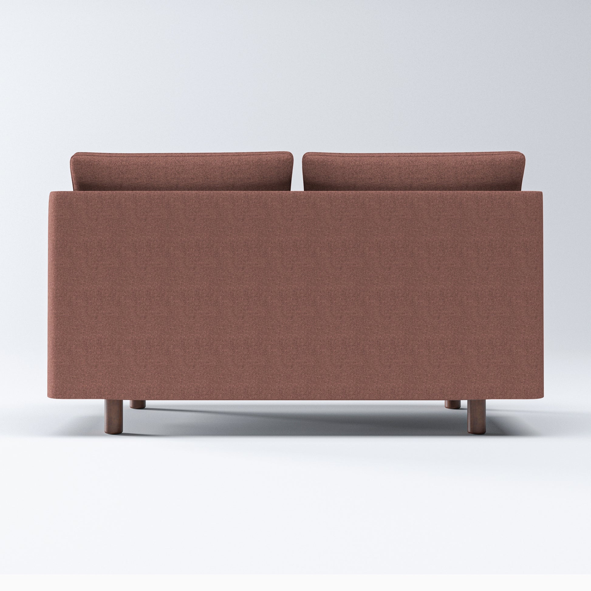 Nora Loveseat in Dusty Rose shown from the rear with a clean upholstered back panel, two visible cushion tops, and short cylindrical brown legs