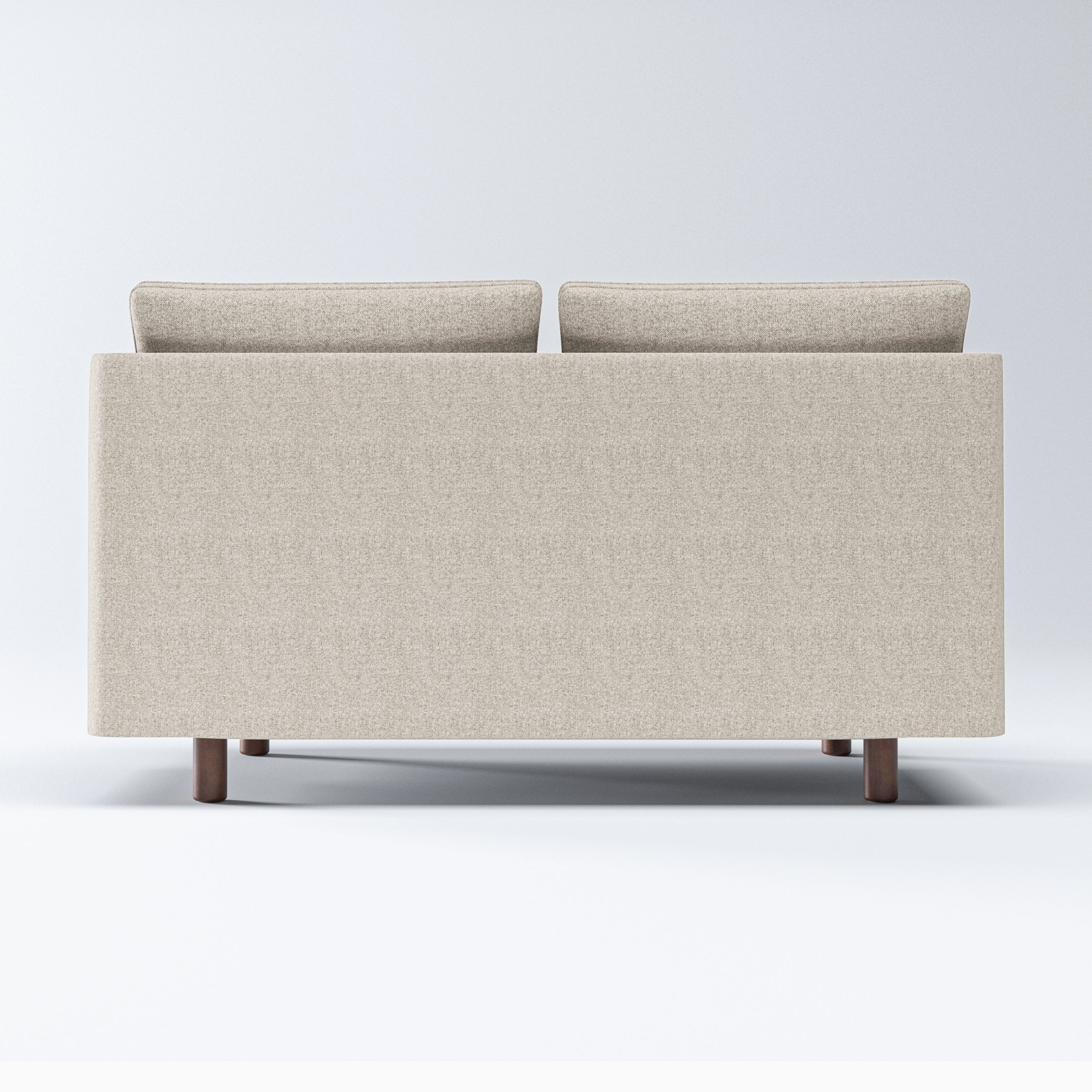 Nora Loveseat in Sandstone Beige shown from behind with a broad upholstered back panel, two cushion tops, and compact cylindrical brown legs.