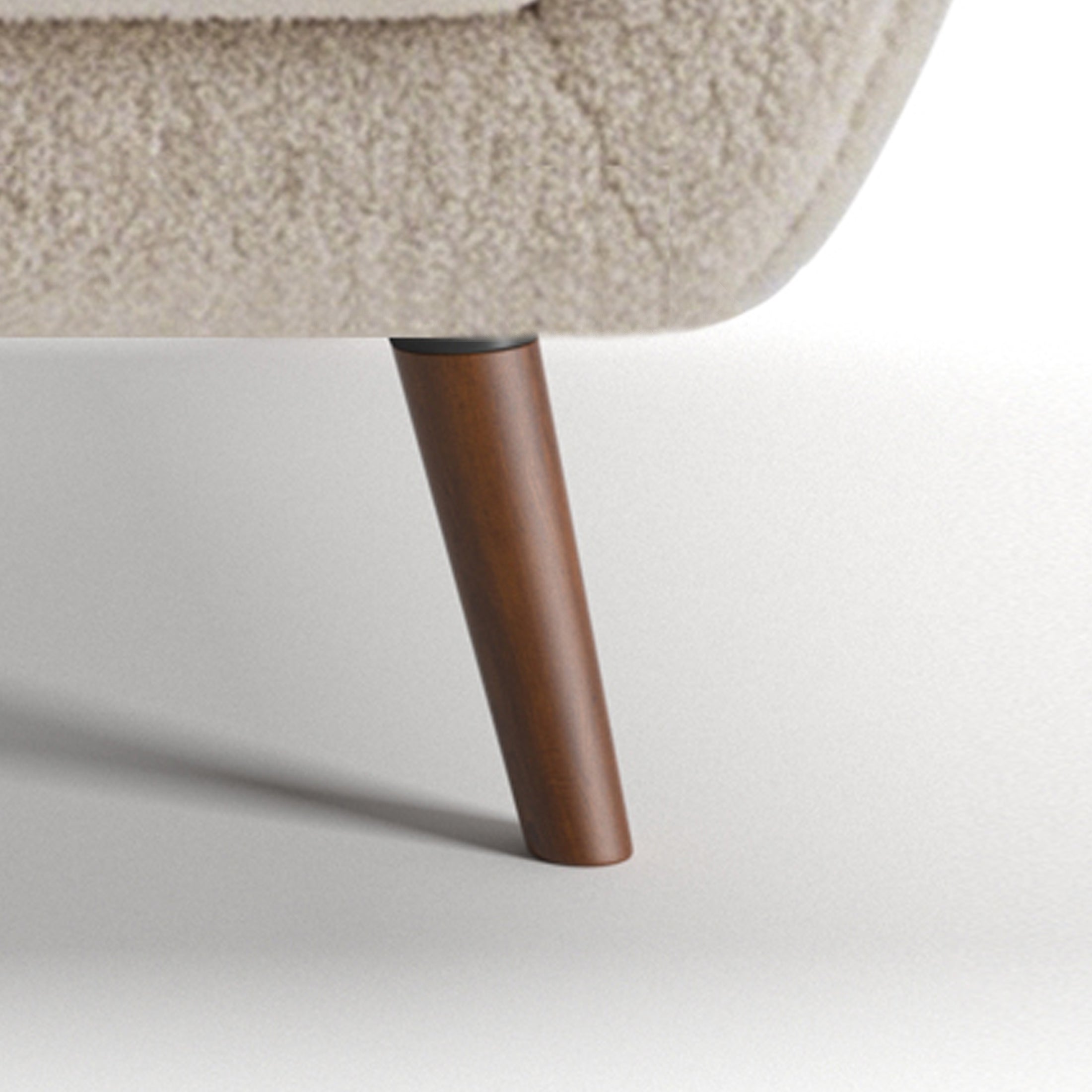 Oakland Loveseat in Boucle Ivory featuring a close-up of the tapered brown leg, dark connector, curved lower frame, and textured ivory upholstery