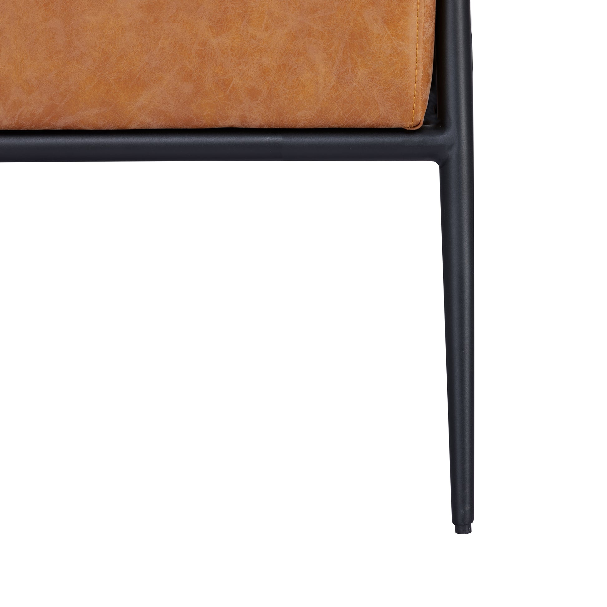 Parker Accent Chair in Faux Leather Camel featuring a close-up of the mottled upholstery, stitched edge, black seat support, frame joint, and tapered metal leg