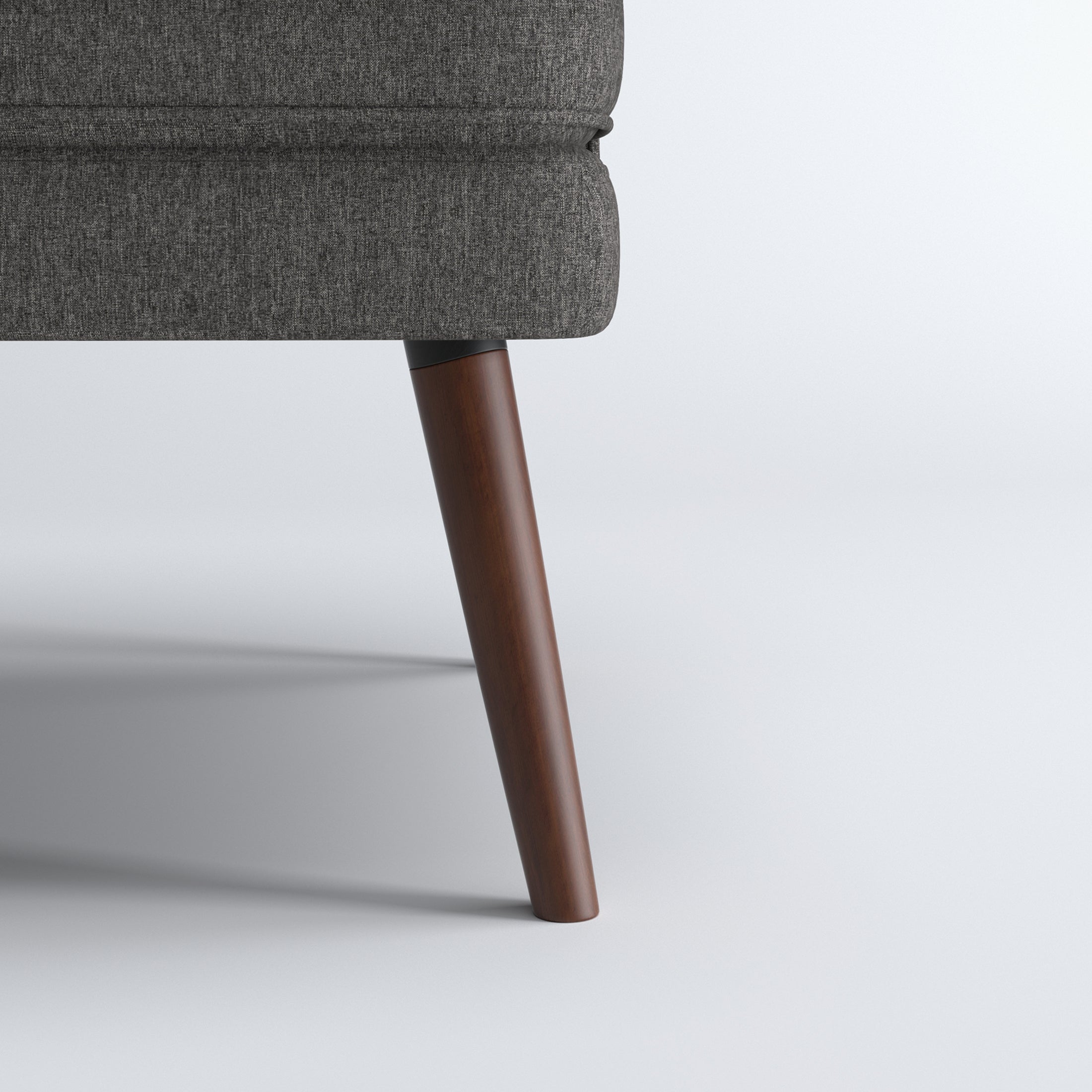 Dana Accent Chair in Faux Linen Dark Gray featuring a close-up of one tapered brown leg beneath the rounded upholstered base and textured faux linen fabric