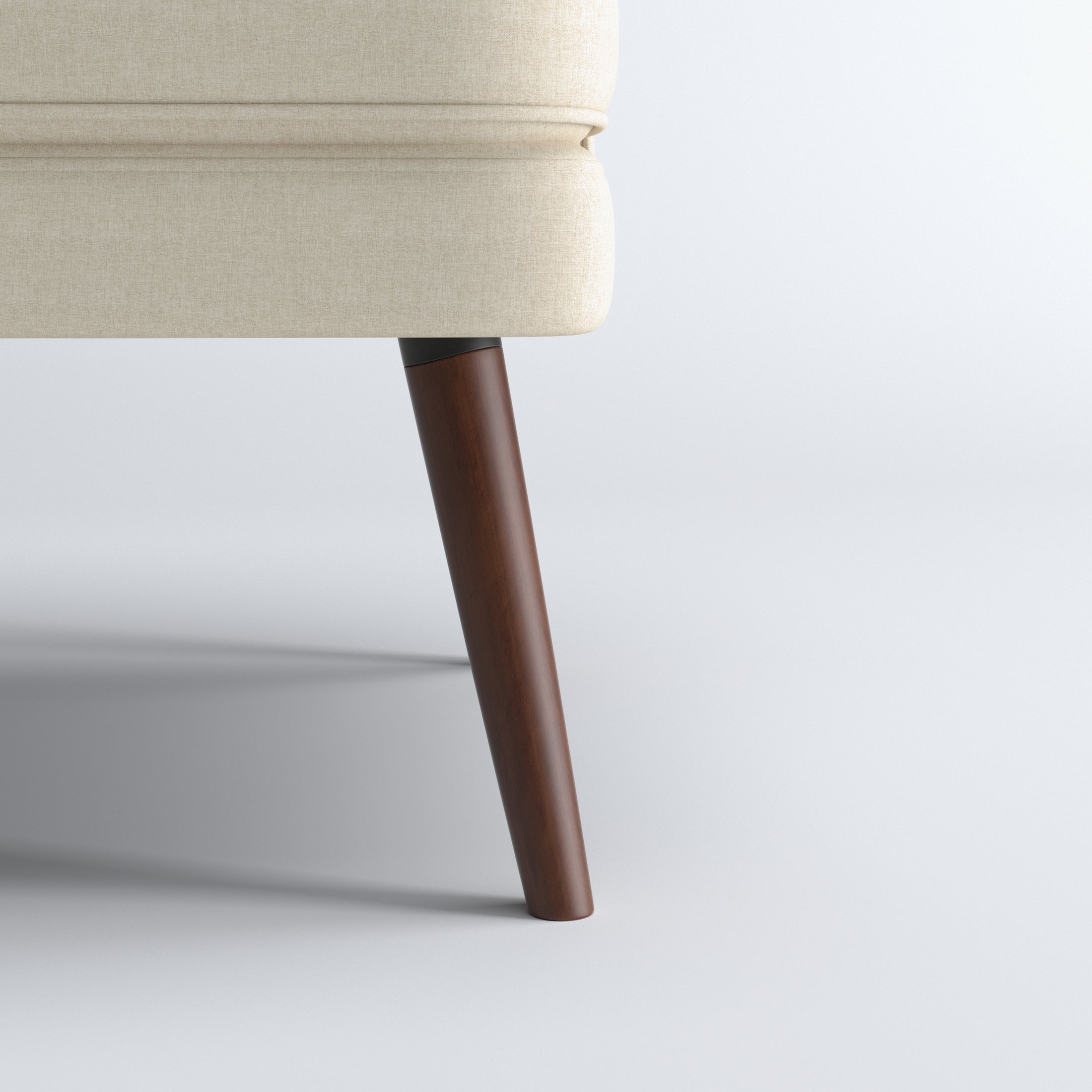 Dana Accent Chair in Faux Linen Beige featuring a close-up of one tapered brown leg beneath the rounded upholstered base and textured faux linen fabric