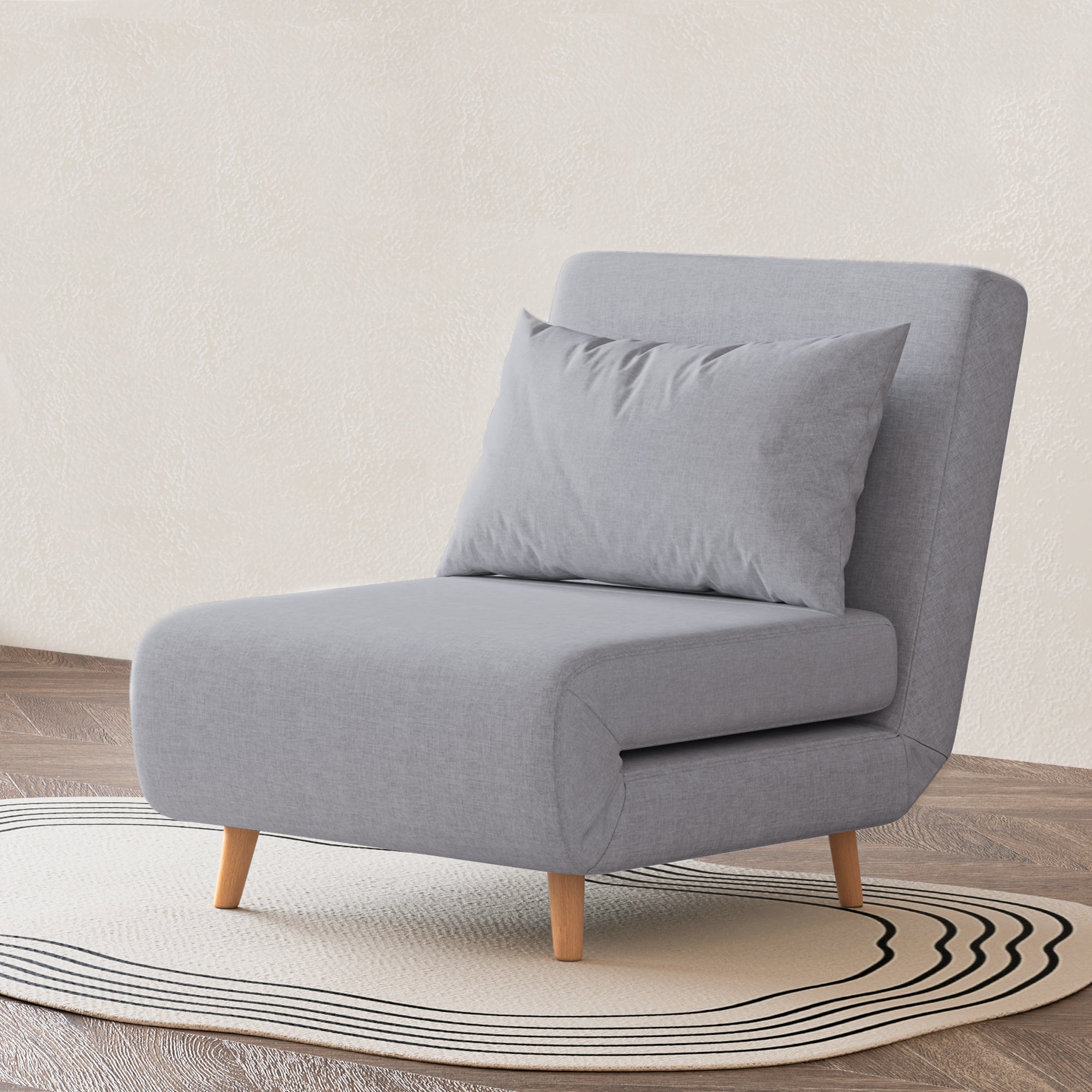 Tustin Convertible Chair in Moonlight styled on a patterned rug with an armless silhouette, matching lumbar pillow, rounded seat, and tapered natural wood legs.