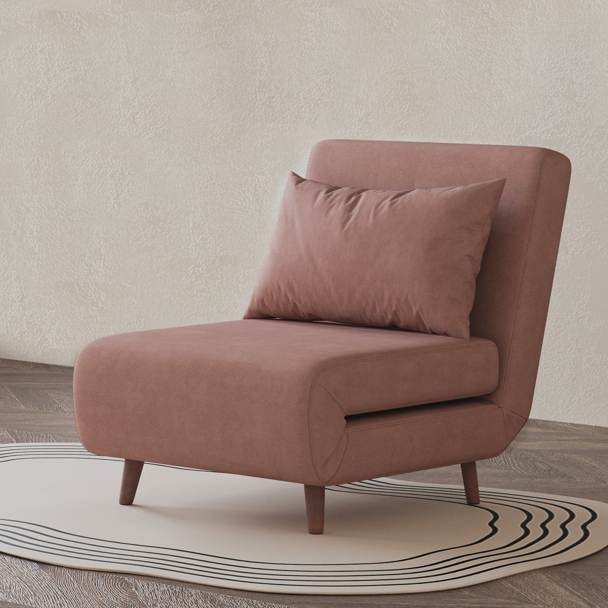 Tustin Convertible Chair in Velvet Blush styled on a patterned rug with an armless silhouette, matching lumbar pillow, rounded seat, and tapered dark brown wood legs.